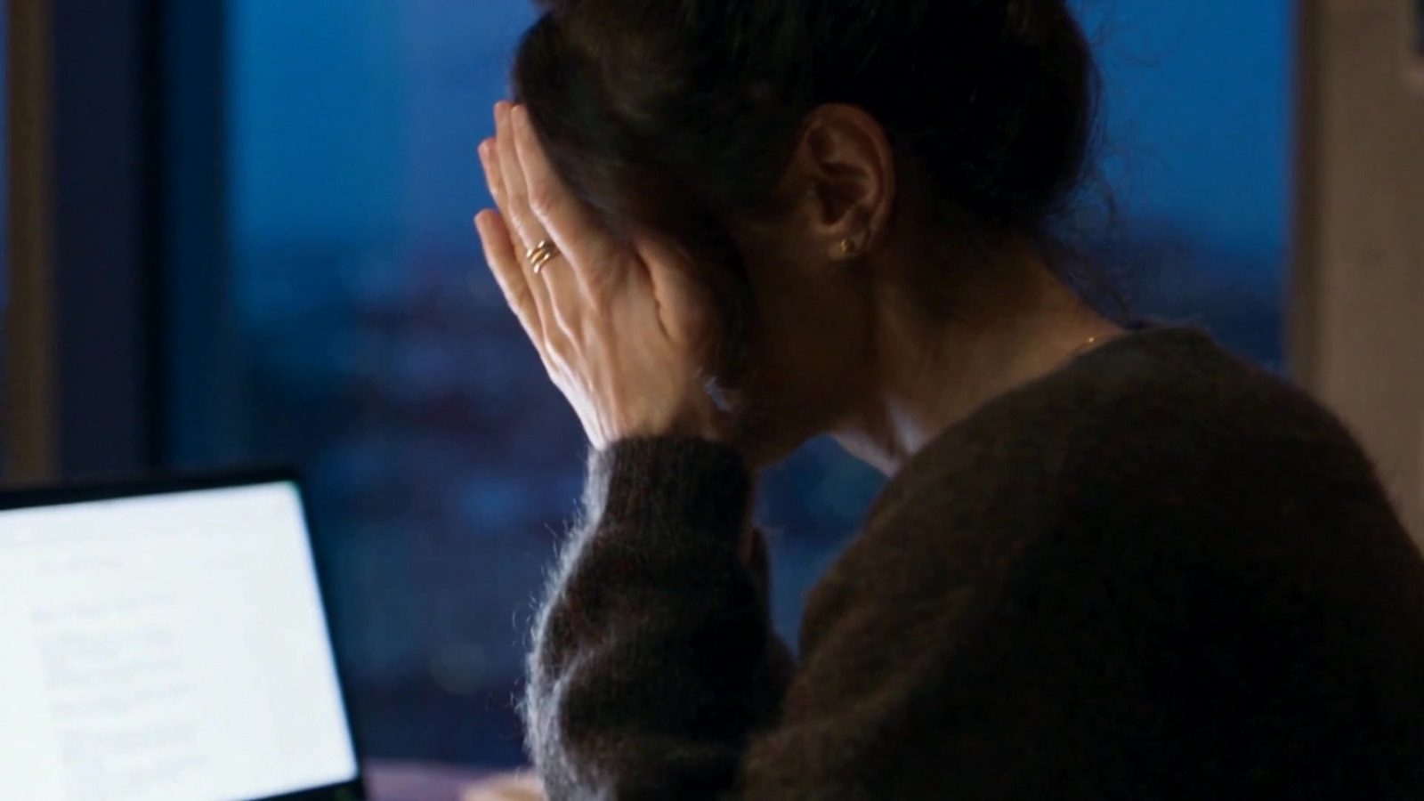A designer late at night at her laptop, exhausted
